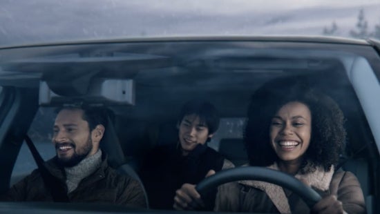 Three passengers riding in a vehicle and smiling | Fort Collins Nissan in Fort Collins CO