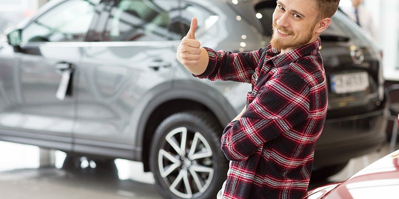 customer giving thumbs up with SUV in background