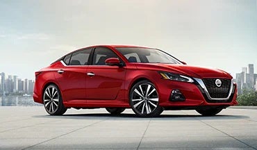 2023 Nissan Altima in red with city in background illustrating last year's 2022 model in Fort Collins Nissan in Fort Collins CO