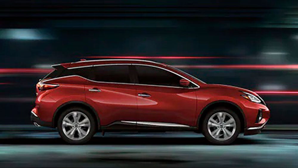 2023 Nissan Murano shown in profile driving down a street at night illustrating performance. | Fort Collins Nissan in Fort Collins CO